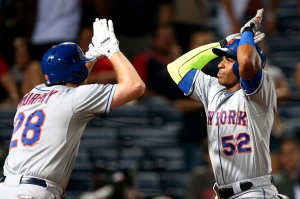 New York Mets' Yoenis Cespedes (52) celebrates with teammate Daniel Murphy after hitting two-run home run during the ninth inning of a baseball game against the Atlanta Braves on Friday, Sept. 11, 2015, in Atlanta. (AP Photo/John Bazemore)